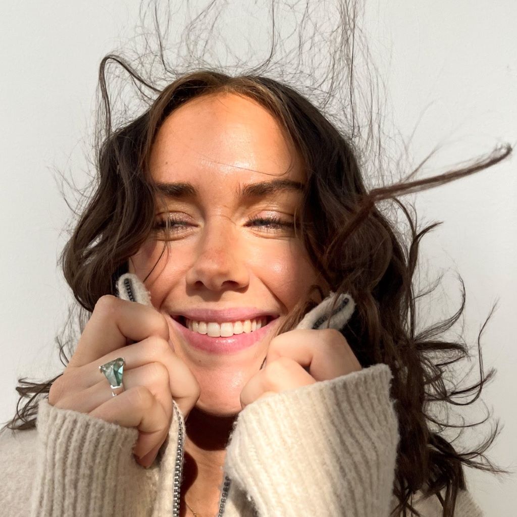 Pretty young brunette girl smiling with white teeth, wearing beige sweater