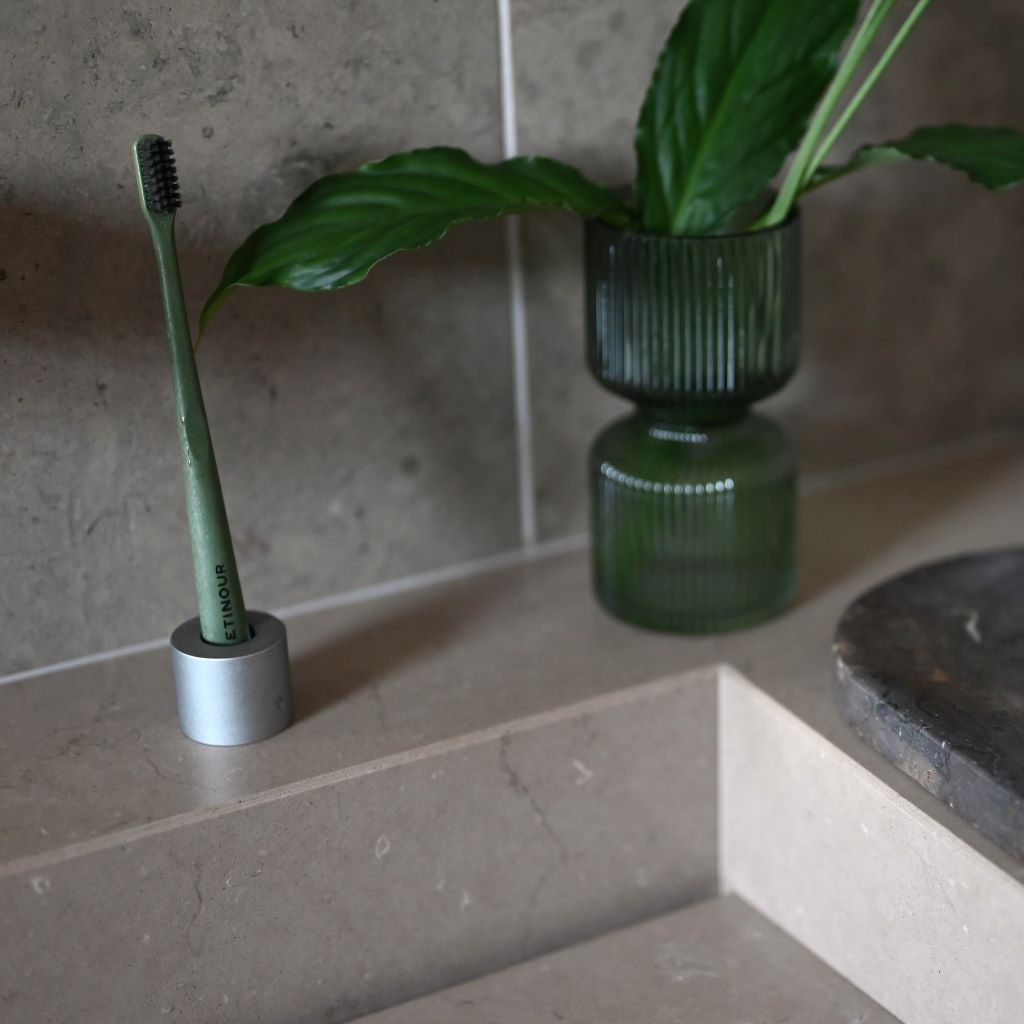 Etinour essential toothbrush in clean bathroom with green plant