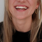 Close-up of blonde girl with black sweater smiling wide and bright